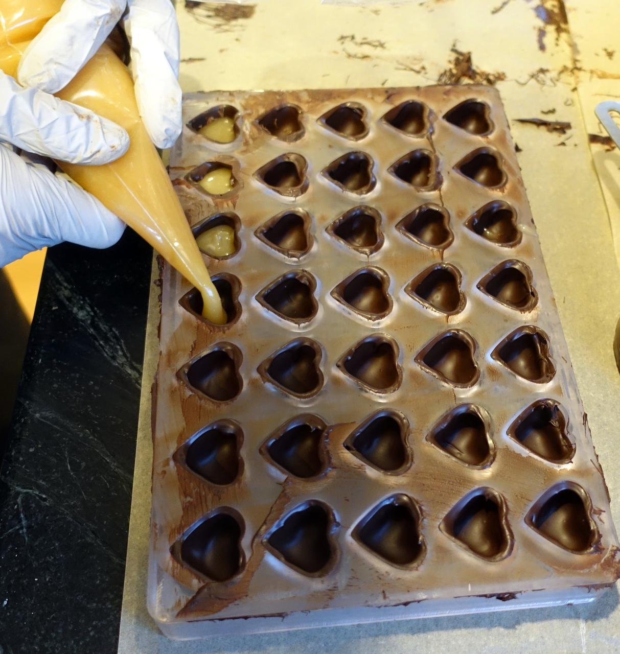 Filling the heart shells with caramel. It looks smooth here, but crystallized a bit over the course of a few days. Should have used some invert sugar, like corn syrup, instead of just sugar.